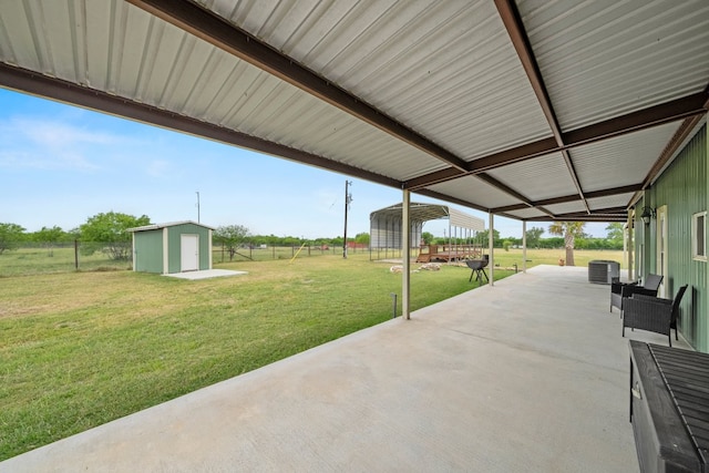 view of patio / terrace featuring central AC, an outbuilding, a shed, and a fenced backyard