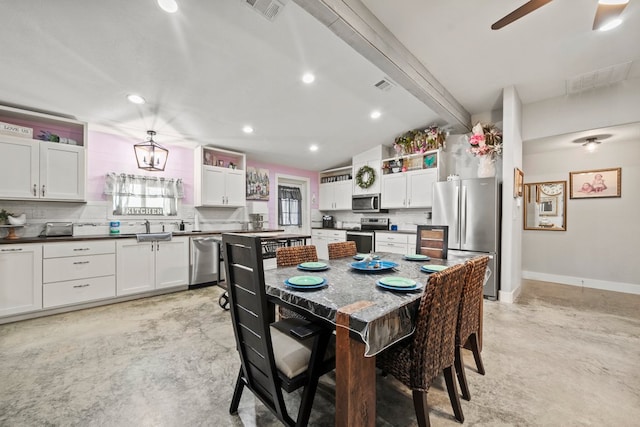 dining area with ceiling fan, finished concrete floors, and visible vents
