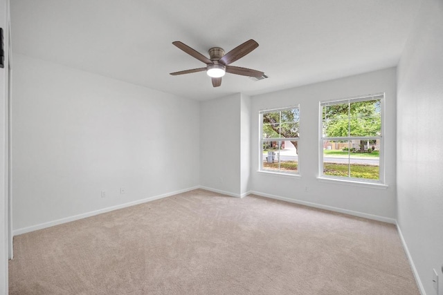spare room with ceiling fan, baseboards, and carpet
