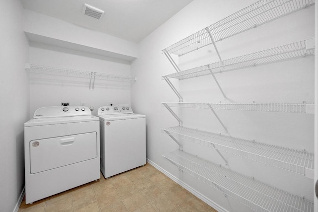 laundry area featuring laundry area, baseboards, separate washer and dryer, and visible vents