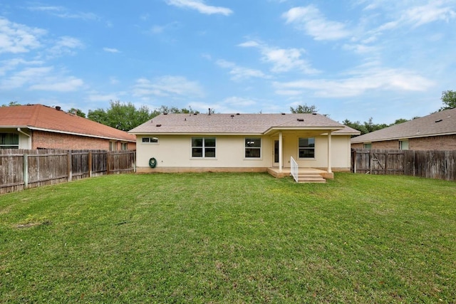 rear view of property with a yard, a fenced backyard, and stucco siding