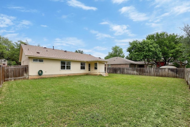 back of property featuring a lawn, a fenced backyard, and stucco siding