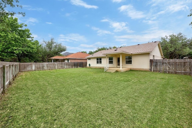rear view of property with a lawn, a fenced backyard, a patio area, and stucco siding