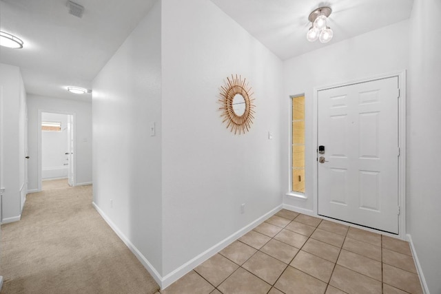 entryway featuring baseboards, light tile patterned flooring, and visible vents