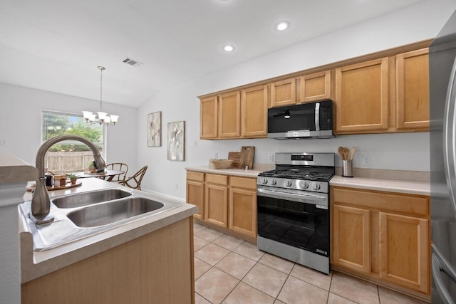 kitchen featuring an inviting chandelier, a sink, appliances with stainless steel finishes, light tile patterned floors, and vaulted ceiling