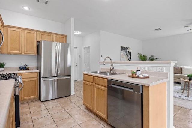 kitchen featuring visible vents, a sink, light tile patterned floors, and stainless steel appliances