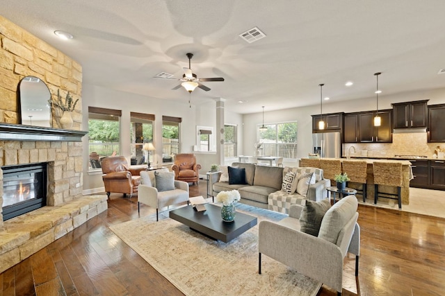 13358 Mesa Verde Dr, Austin, TX 78737 - living room featuring a ceiling fan, wood-type flooring, a stone fireplace, and recessed lighting