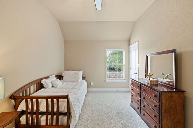 bedroom featuring baseboards, light carpet, and lofted ceiling