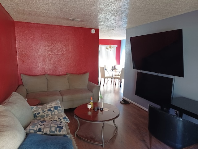 913 N 19th St, Copperas Cove, TX 76522 - living room with a chandelier, a textured ceiling, wood finished floors, and baseboards