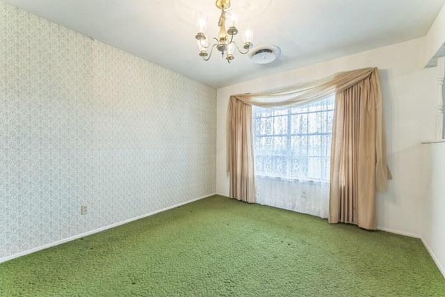 carpeted empty room featuring an inviting chandelier and wallpapered walls