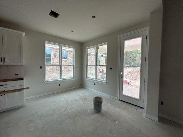 unfurnished dining area featuring baseboards and plenty of natural light