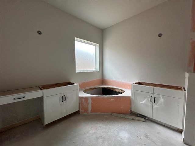full bath featuring concrete floors and a garden tub