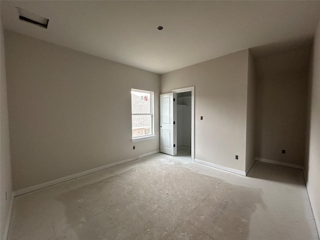 unfurnished bedroom featuring baseboards and a walk in closet