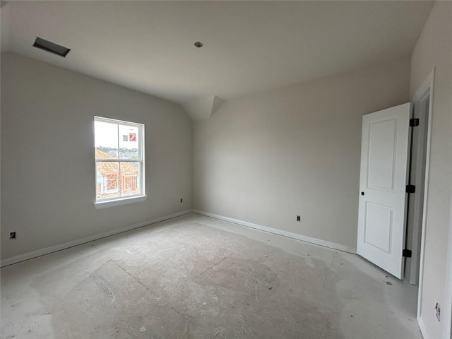 empty room with baseboards and vaulted ceiling