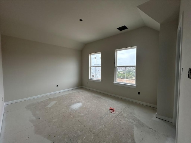 unfurnished room with baseboards and vaulted ceiling