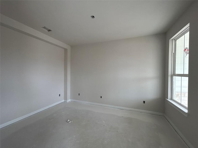 unfurnished room featuring baseboards, visible vents, and unfinished concrete floors