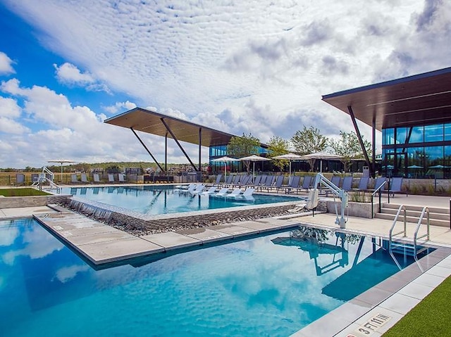 pool with a patio area and fence