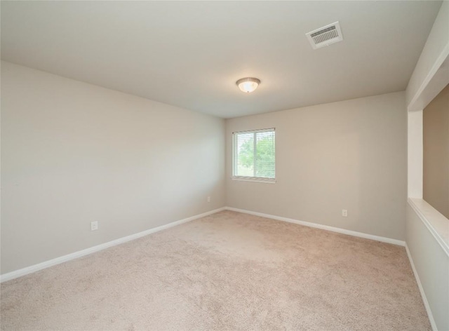 spare room featuring visible vents, baseboards, and light colored carpet