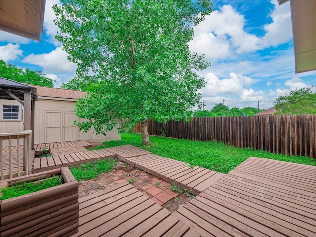 wooden terrace featuring a yard and a fenced backyard