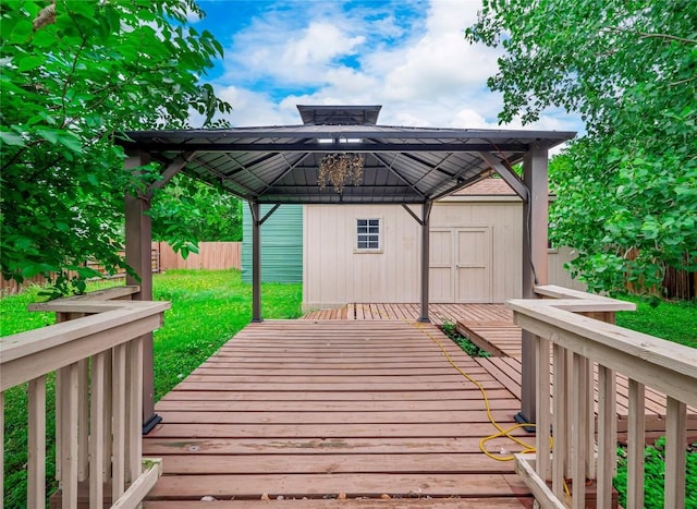 wooden deck with a storage shed, an outbuilding, a gazebo, fence, and a yard