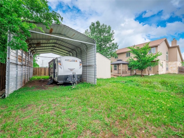 view of yard with a gazebo, fence, and a carport