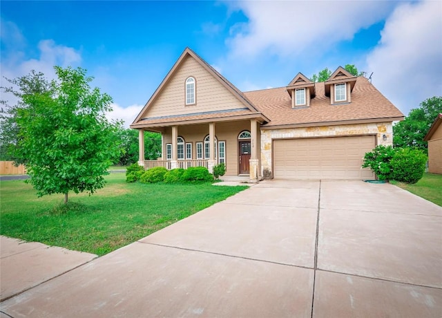 800 Savannah Cv, Elgin, TX 78621 - view of front of property featuring covered porch, a front lawn, driveway, stone siding, and an attached garage