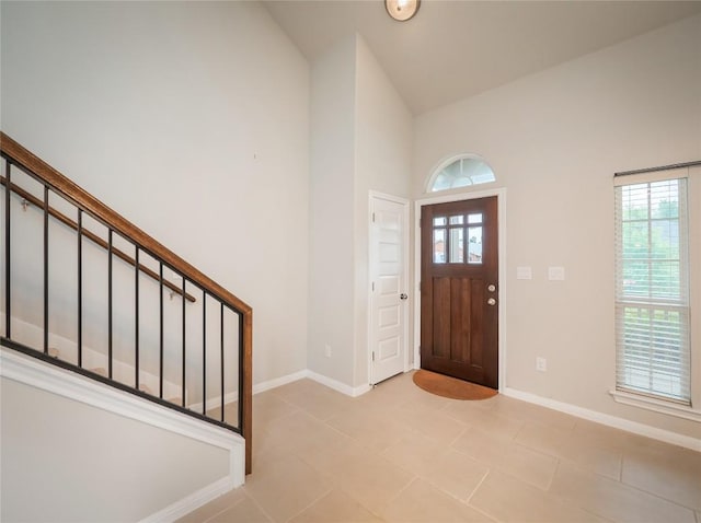 800 Savannah Cv, Elgin, TX 78621 - foyer entrance with high vaulted ceiling, stairs, and light tile patterned floors