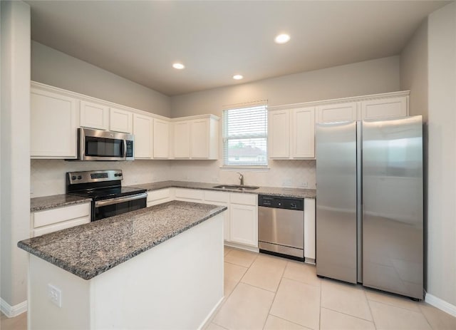 kitchen with a sink, decorative backsplash, appliances with stainless steel finishes, and white cabinetry