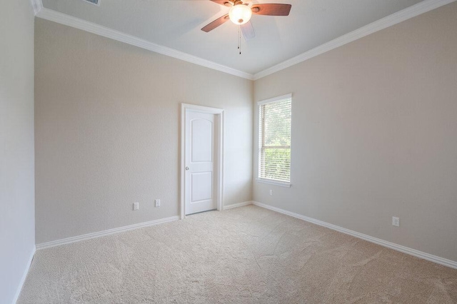 empty room featuring crown molding, baseboards, ceiling fan, and carpet flooring