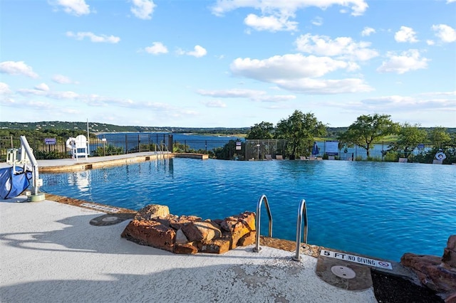 community pool featuring fence and a patio