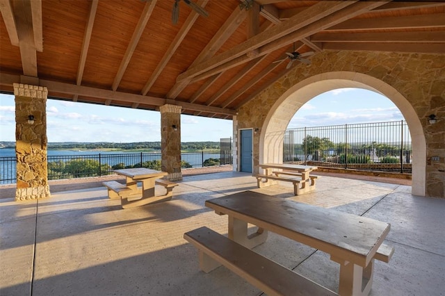 surrounding community featuring a water view, fence, and a patio area