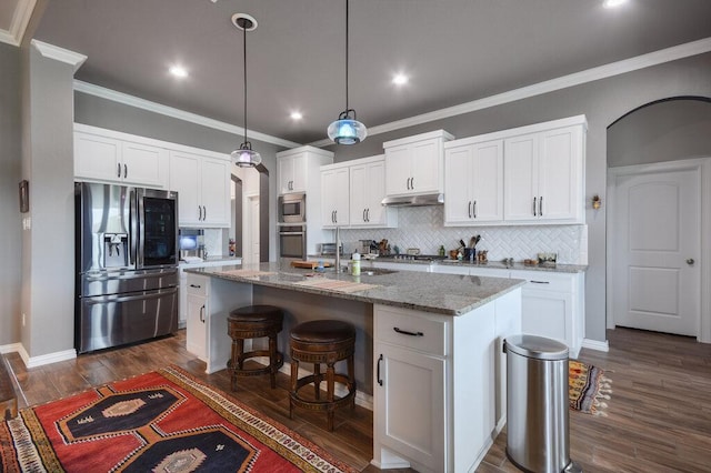 kitchen featuring white cabinets, stainless steel appliances, arched walkways, and backsplash