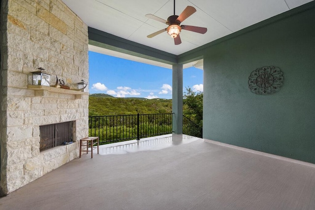 view of patio / terrace featuring an outdoor stone fireplace and a ceiling fan