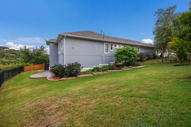 exterior space featuring a lawn and fence