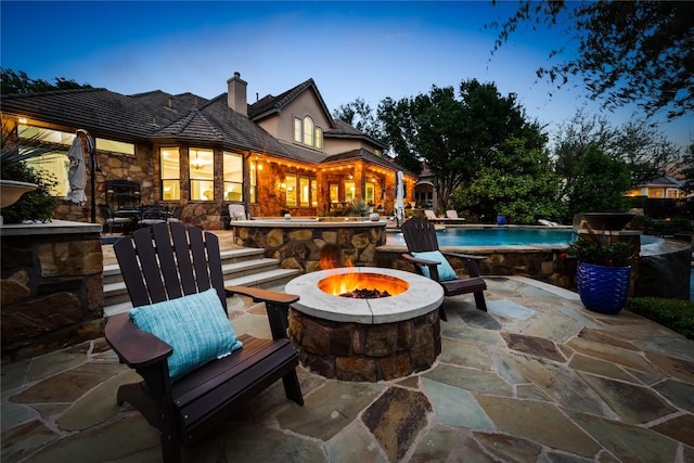 exterior space with a fire pit and an outdoor pool