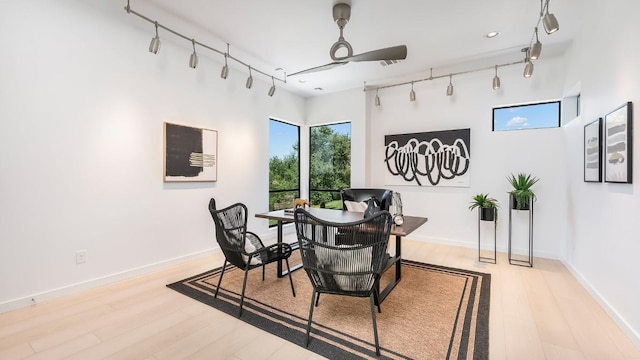 dining space with ceiling fan, track lighting, baseboards, and wood finished floors