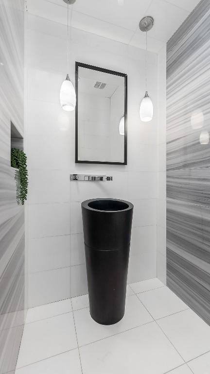 bathroom with tile patterned floors and tile walls