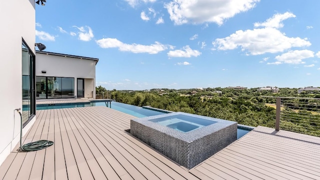 wooden terrace featuring an infinity pool and an in ground hot tub