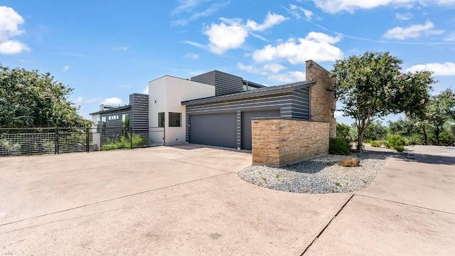 view of side of property featuring a garage, fence, and concrete driveway