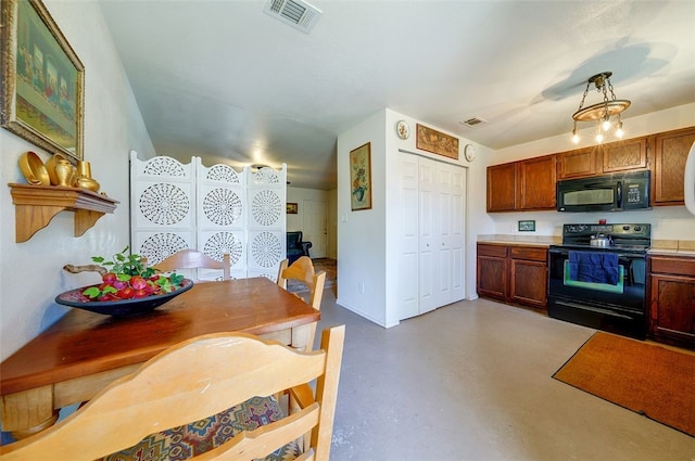 kitchen with light countertops, black appliances, concrete floors, and visible vents