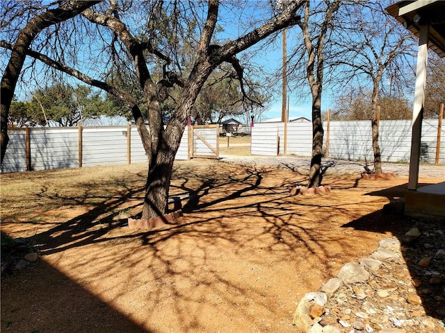 view of yard featuring a storage unit, a fenced backyard, and an outdoor structure