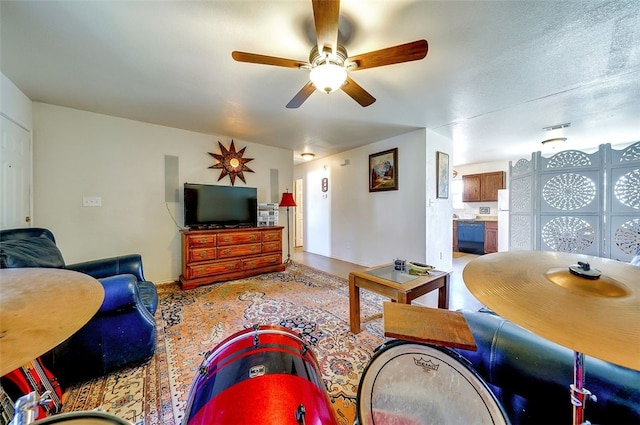 living room featuring baseboards and ceiling fan
