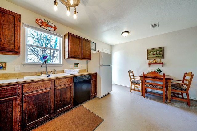 kitchen with visible vents, a sink, light countertops, freestanding refrigerator, and black dishwasher