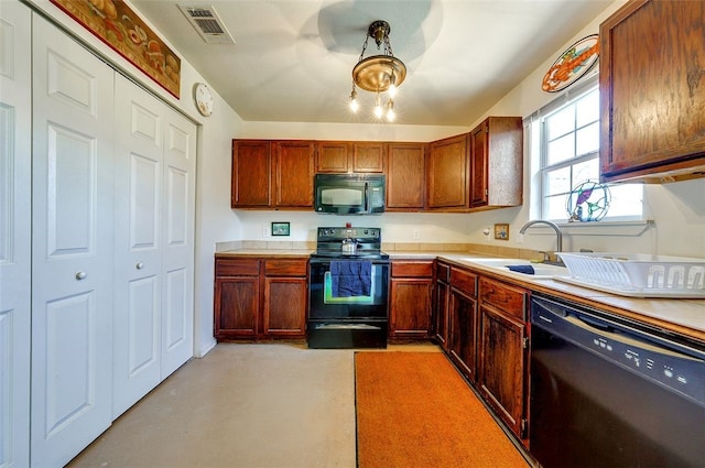kitchen featuring visible vents, light countertops, a sink, concrete floors, and black appliances