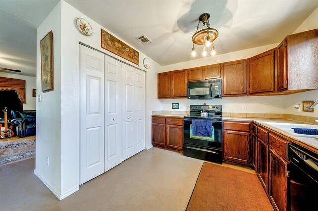 kitchen featuring visible vents, brown cabinetry, light countertops, a sink, and black appliances
