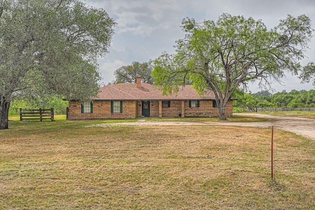 ranch-style home featuring fence, a chimney, and a front yard