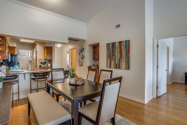 3404 American Dr Unit 2306, Lago Vista, TX 78645 - dining space featuring light wood-type flooring, baseboards, crown molding, and visible vents
