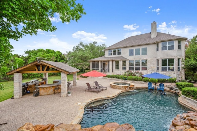 rear view of house with a patio, a chimney, a sunroom, exterior kitchen, and a gazebo