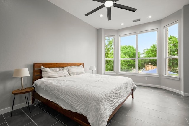 tiled bedroom featuring baseboards, visible vents, and multiple windows