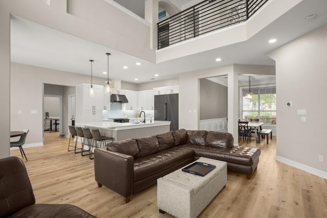 living area with recessed lighting, baseboards, and light wood finished floors
